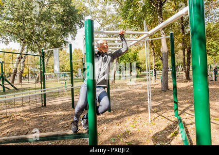 Attiva donna Senior di esercitarsi in pubblico parco sportivo, uno stile di vita sano persone mature. Foto Stock