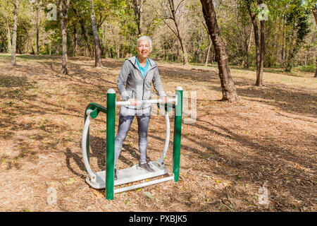 Donna anziana in abbigliamento sportivo che esercitano a Outdoor Fitness Park, uno stile di vita sano persone mature. Foto Stock