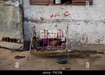 I rifugiati palestinesi bambino giocare al di fuori della loro casa temporanea nel nord della Striscia di Gaza città di Beit Lahia. Un numero crescente di famiglie si affaccia la povertà dopo la perdita del lavoro durante gli ultimi dieci anni di assedio di Gaza e di tre guerre israeliane sulla striscia di Gaza. Foto Stock