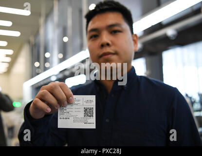 (181021) -- ZHUHAI, Ottobre 21, 2018 (Xinhua) -- Un lavoratore personale presenta il documento di identificazione a Macao a Zhuhai Porto di Hong Kong-Zhuhai-ponte di Macao a Zhuhai Cina del sud della provincia di Guangdong, 11 ott. 2018. Lo sdoganamento tra Macao e Zhuhai sarà effettuata su di un' ispezione congiunta e un tempo di rilascio' principio, al fine di rendere il processo efficiente per i viaggiatori che usano la Hong Kong-Zhuhai-ponte di Macao. Sotto il nuovo sistema doganale, viaggiatori sarà richiesto di passare i controlli di frontiera solo una volta -- né mediante automatico, semi-automatico, o canali presidiato in funzione o Foto Stock