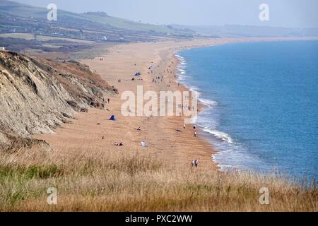 Dorset, Regno Unito. 21 ott 2018. Le persone godono di un clima caldo e alla spiaggia di alveare a Burton Bradstock nel Dorset Credito: Finnbarr Webster/Alamy Live News Foto Stock