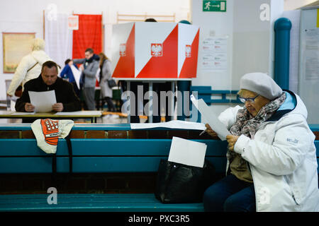 Varsavia, Polonia. Xxi oct, 2018. Una donna che legge le schede di voto durante le elezioni locali al giorno. Il 21 ottobre 2018 il polacco cittadini voteranno per migliaia di consiglieri e sindaci locali in ambito regionale, county e parrocchia elezioni. Credito: Omar Marques/SOPA Immagini/ZUMA filo/Alamy Live News Foto Stock