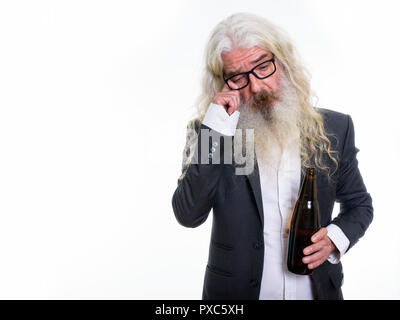 Studio shot di sad senior barbuto imprenditore tenendo una bottiglia di Foto Stock