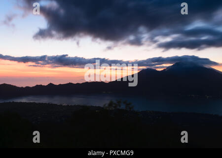 Sunrise vista dal Gunung Batur vulcano a Bali, in Indonesia con silhouette visibile del Monte Agung vulcano Rinjani e montagne Foto Stock