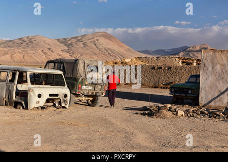 Abitante in bright shirt passeggiate nel villaggio Bulunkul, Bulunkul, il Pamir Highway, Pamir Mountains, Tagikistan Foto Stock