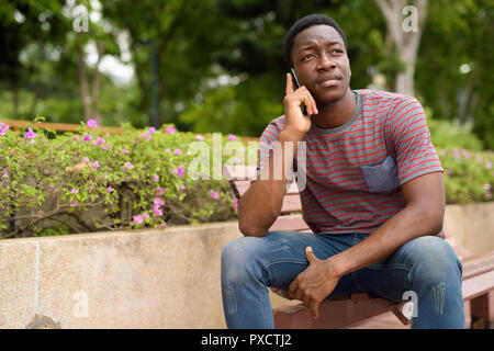 I giovani africani bello uomo che parla al telefono in posizione di parcheggio Foto Stock