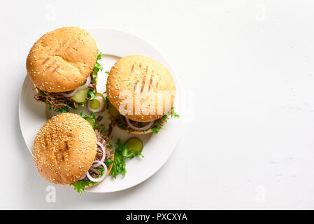 Tirato hamburger di manzo con verdure sulla piastra bianca su sfondo di pietra con copia spazio. Vista superiore Foto Stock