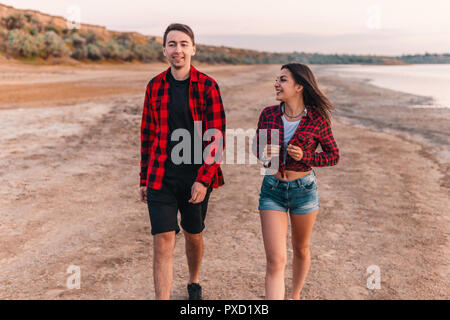 Oung giovane sulla spiaggia camminando insieme Foto Stock