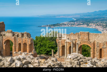 Rovine dell'antico Teatro Greco di Taormina con la costa siciliana. Provincia di Messina, Sicilia, Italia meridionale. Foto Stock
