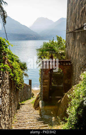 Ripide scale di pietra in stretto vicolo al lago di Como al Lago turistico villaggio, girato in caduta luminosa luce a San Siro, Como, Italia Foto Stock