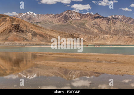 Cammelli Bactrian su un lontano sandspit al bellissimo lago Yashilkul, Bulunkul, Pamir Mountains, Gorno Badakshan Regione autonoma, Tagikistan Foto Stock