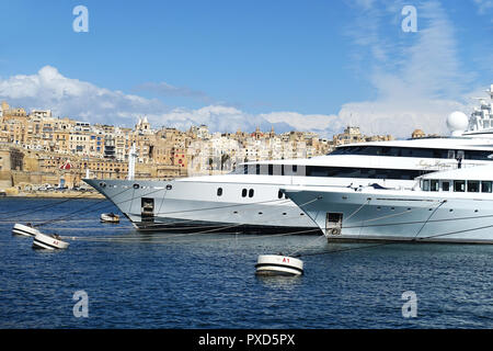 Superyacht ormeggiata in Dockyard Creek, Grand Harbour di Malta, con la città di La Valletta dietro Foto Stock