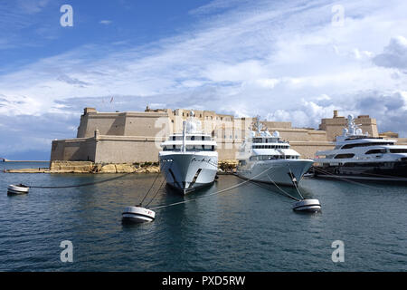 Skyscape drammatica su Fort St Angelo, Malta, con superyacht ormeggiata in primo piano Foto Stock