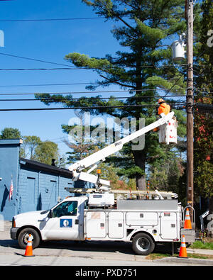 Un lavoratore in una piattaforma di lavoro aerea collegando i cavi a fibra ottica per le nuove connessioni a internet ad alta velocità. Foto Stock