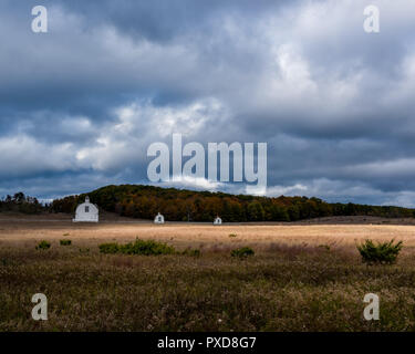 Bianco del diciannovesimo secolo edifici agricoli sullo storico di D.H. Giorno fattoria con drammatico il cielo di autunno. Sleeping Bear Dunes National Lakeshore, Michigan, Stati Uniti d'America. Foto Stock