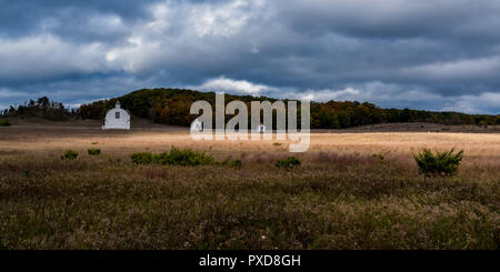 Bianco del diciannovesimo secolo edifici agricoli sullo storico di D.H. Giorno fattoria con drammatico il cielo di autunno. Sleeping Bear Dunes National Lakeshore, Michigan, Stati Uniti d'America. Foto Stock