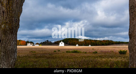 Bianco del diciannovesimo secolo edifici agricoli sullo storico di D.H. Giorno fattoria con drammatico il cielo di autunno. Sleeping Bear Dunes National Lakeshore, Michigan, Stati Uniti d'America. Foto Stock