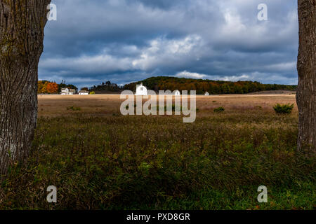 Bianco del diciannovesimo secolo edifici agricoli sullo storico di D.H. Giorno fattoria con drammatico il cielo di autunno. Sleeping Bear Dunes National Lakeshore, Michigan, Stati Uniti d'America. Foto Stock