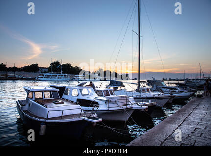Piccole barche e yacht ormeggiati nel porto di Zadar, guardando verso la Città Vecchia al tramonto Foto Stock