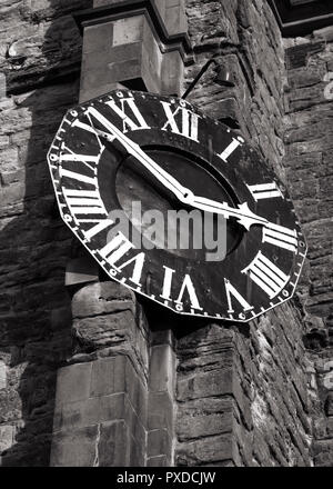 Vintage numeri romani orologio su un vecchio muro stonw in bianco e nero. Foto Stock