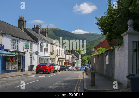 Strada nel villaggio di Rostrevor County Giù in una giornata estiva di sole con Kilbroney Forest Park in background. Foto Stock