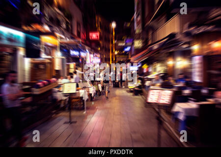Movimento sfocate immagini di persone a camminare su una strada in Taksim /Beyoglu zona di notte a Istanbul. La posizione è una vivace vita notturna, i negozi e i ristoranti di dist Foto Stock