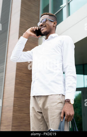 Positivo l'uomo africano chiamata partner aziendali esterni Foto Stock