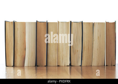 Fila di vecchi libri isolato con ripiano in legno. Foto Stock