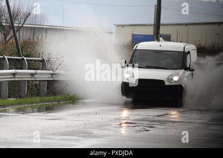Il maltempo - vetture schizzi nella pozza di acqua Foto Stock