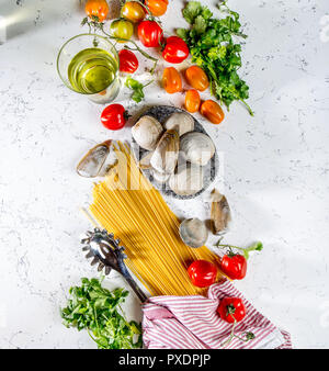 Gli ingredienti per cucinare gli spaghetti con frutti di mare. Gusci musselsa, vongole, vongole, pomodori e vino bianco. Foto Stock