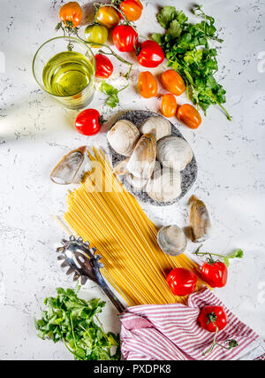 Gli ingredienti per cucinare gli spaghetti con frutti di mare. Gusci musselsa, vongole, vongole, pomodori e vino bianco. Foto Stock