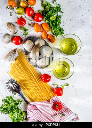 Gli ingredienti per cucinare gli spaghetti con frutti di mare. Gusci musselsa, vongole, vongole, pomodori e vino bianco. Foto Stock