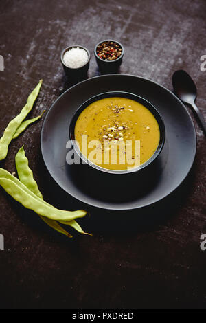 Zuppa cremosa con pisello verde in una ceramica piastra bianca Foto Stock