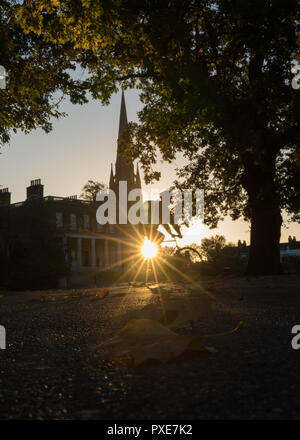 Londra, Regno Unito. 22 ottobre, 2018. Regno Unito meteo, bellissima alba autunnale in Clissold Park, Stoke Newington, Londra. Vista verso Clissold casa con la chiesa di Santa Maria sul lato destro. Silhouette di un ciclista. Credito: Carol moiré / Alamy Live News Foto Stock