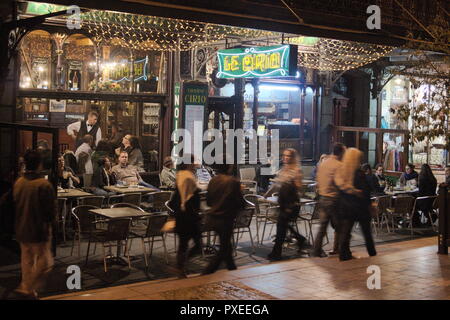 Scena notturna a Bruxelles, Belgio. Turisti e locali in un elegante caffè di fine secolo nel cuore della città storica. Foto Stock