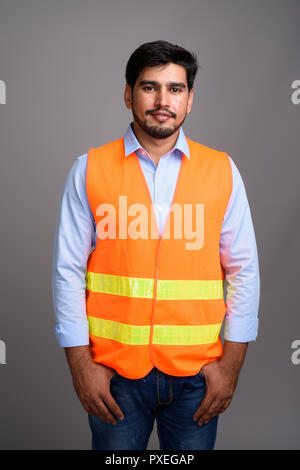 Giovane bello persiano barbuto uomo lavoratore edile contro g Foto Stock