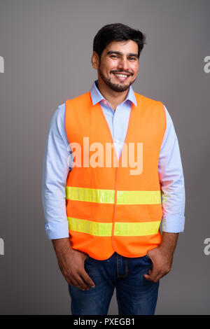 Giovane bello persiano barbuto uomo lavoratore edile contro g Foto Stock