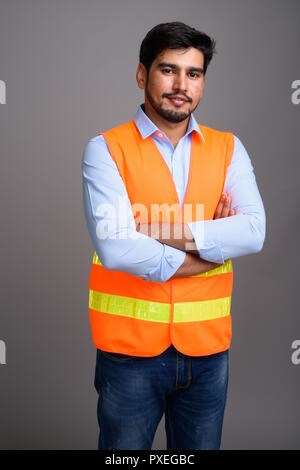 Giovane bello persiano barbuto uomo lavoratore edile contro g Foto Stock