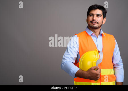 Giovane bello persiano barbuto uomo lavoratore edile contro g Foto Stock