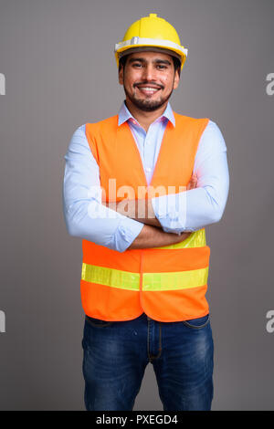 Giovane bello persiano barbuto uomo lavoratore edile contro g Foto Stock