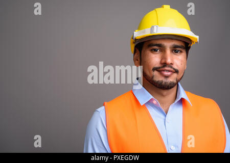 Giovane bello persiano barbuto uomo lavoratore edile contro g Foto Stock