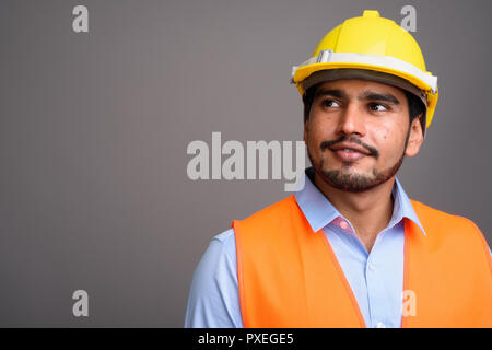 Giovane bello persiano barbuto uomo lavoratore edile contro g Foto Stock