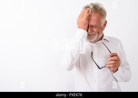 Studio shot di sad senior uomo barbuto tergi le lacrime mentre hol Foto Stock