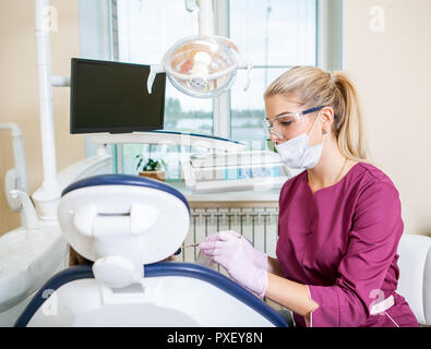 Femmina di dentista in studio dentistico considera i denti con kid paziente Foto Stock