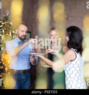 I giovani aventi alcuni frutti con champagne mentre celebrare in una festa di Capodanno Foto Stock