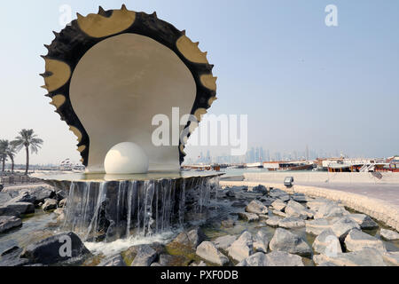 Doha / Qatar - 10 Ottobre 2018: il Monumento della Perla su Doha corniche, con dhow tradizionale ed i grattacieli di West Bay area nel dista Foto Stock