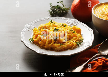 Tagliatelle con crema di zucca salsa su sfondo nero Foto Stock