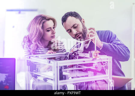 Paio di uomini di affari in piedi vicino al grande moderna stampante laser nel loro ufficio Foto Stock