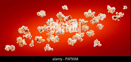 Il Popcorn isolato su sfondo rosso. La caduta o battenti popcorn. Close-up Foto Stock