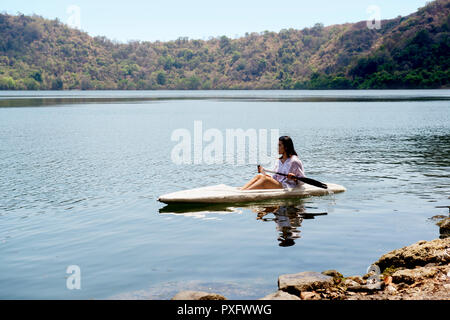 Asian lady canoa kayak sul lago in Isola di satonda. Sumbawa, Indonesia Foto Stock